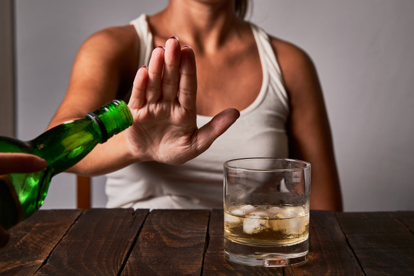 a woman s hand saying don t put any more drink in her glass concept of alcoholism and not drinking to drive