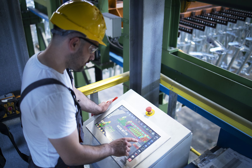 pracownik fabryki zdalny monitoring maszyn przemyslowych i produkcji w sterowni
