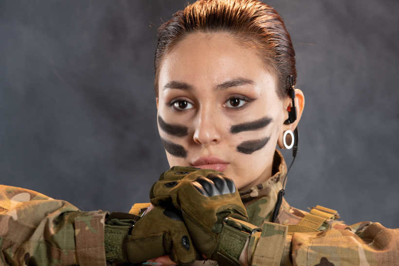 front view female soldier camouflage dark wall