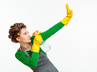 woman spraying windows posing with yellow rubber hands