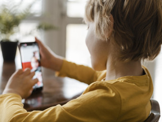 side view boy using smartphone home