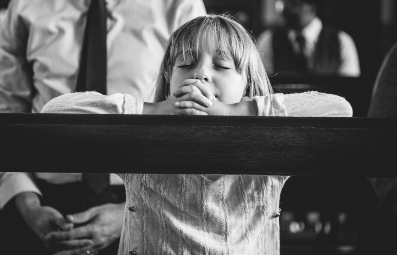 child praying inside church